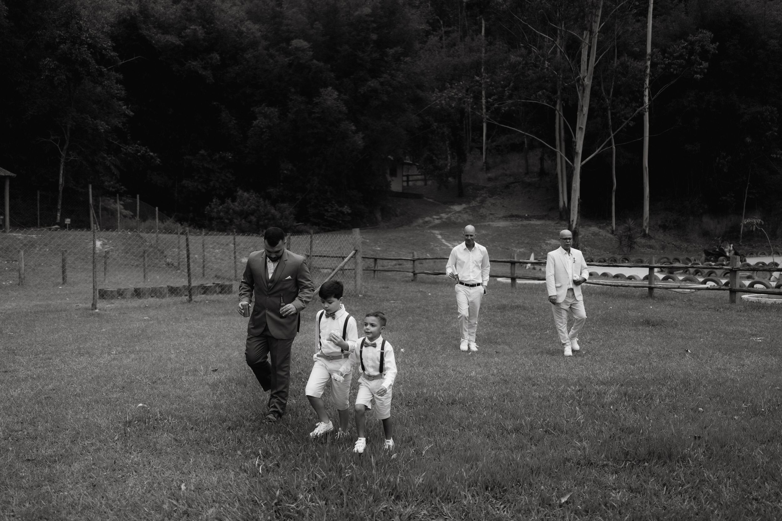 Black and white photo of guests walking across a grassy field.