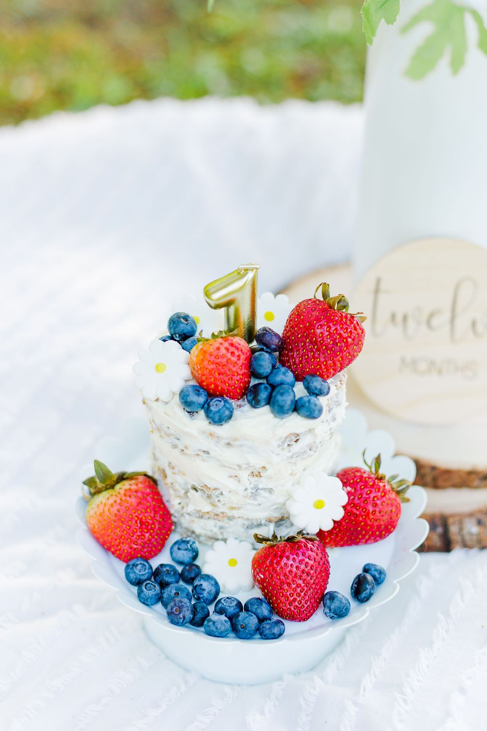Birthday dessert decorated with fresh berries, daisies and gold number one topper.