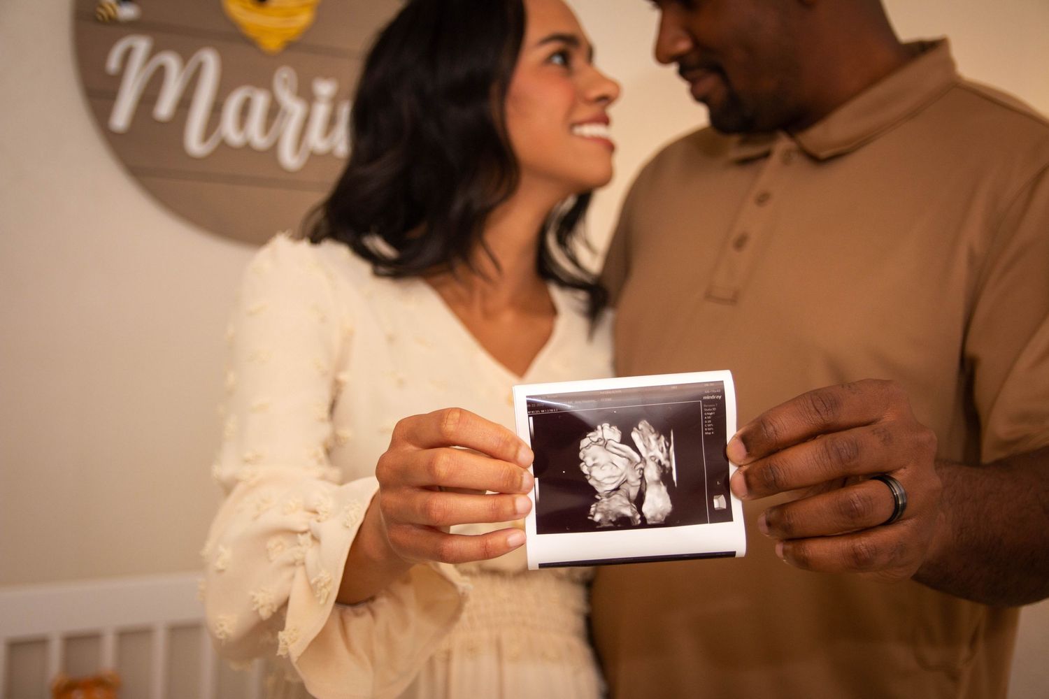 Man and woman holding an ultrasound announcing their pregnancy.