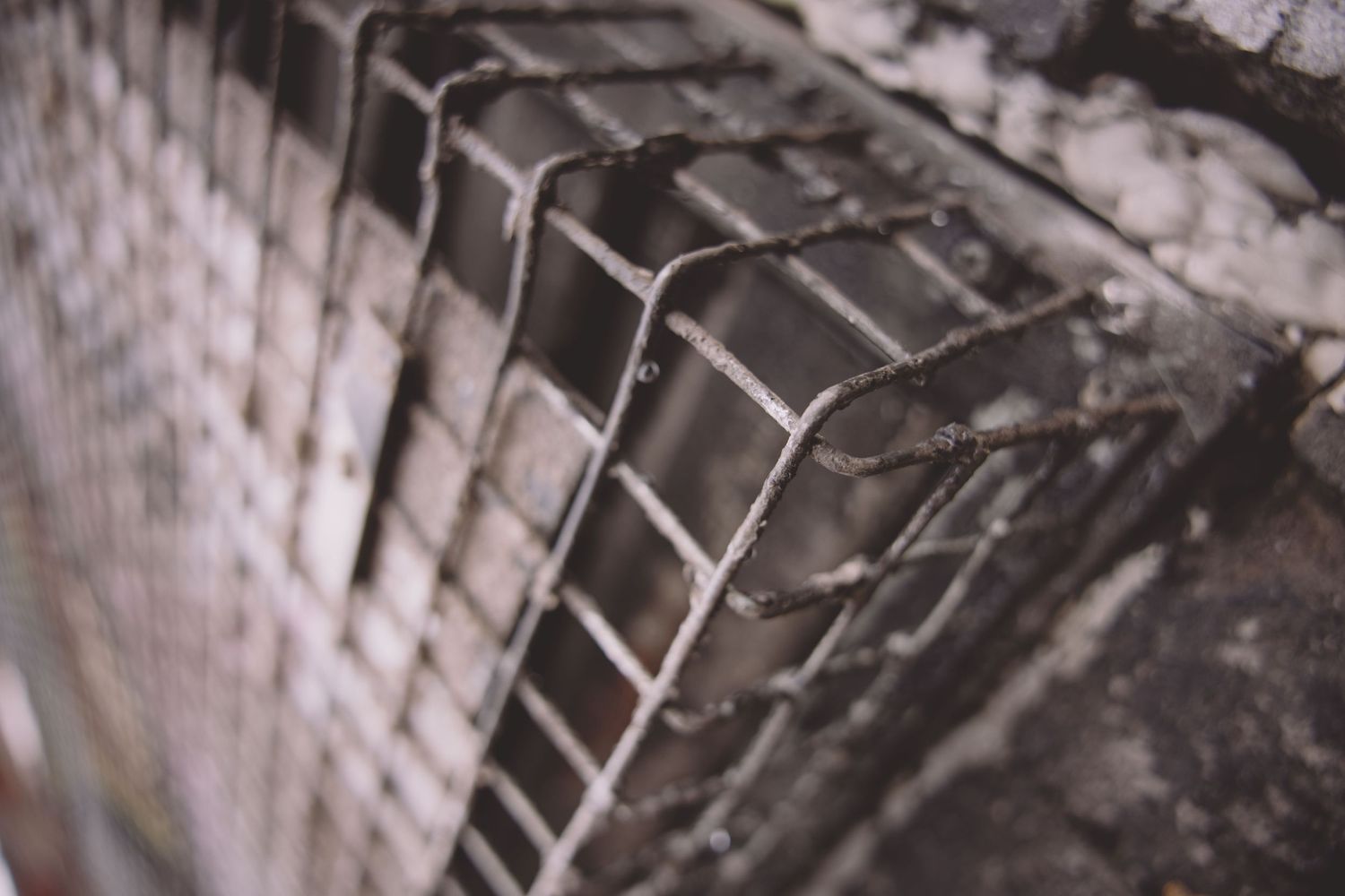 Close-up detail of concrete or metal lattice structure in black and white.