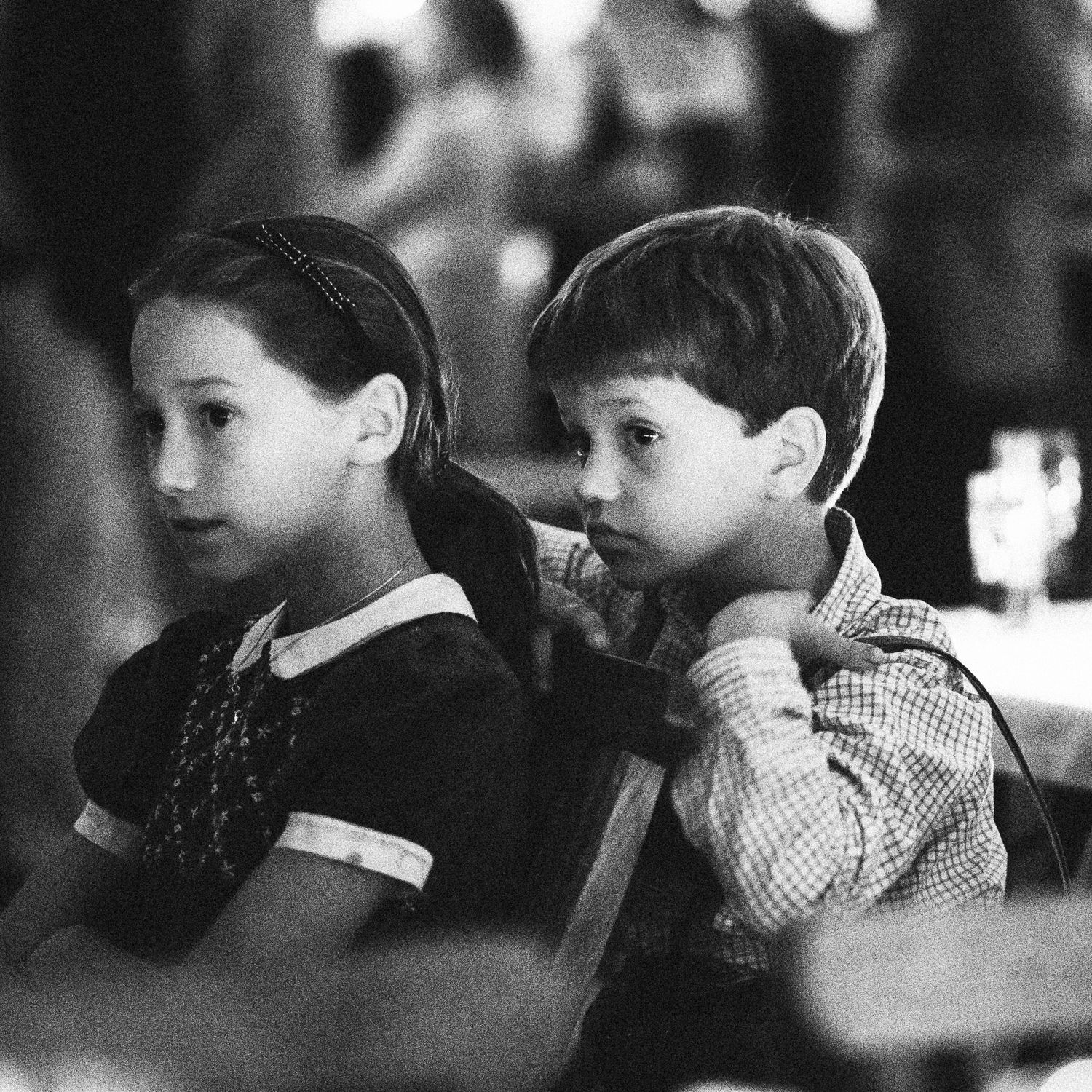 Vintage black and white portrait of two young children sitting together in formal attire.