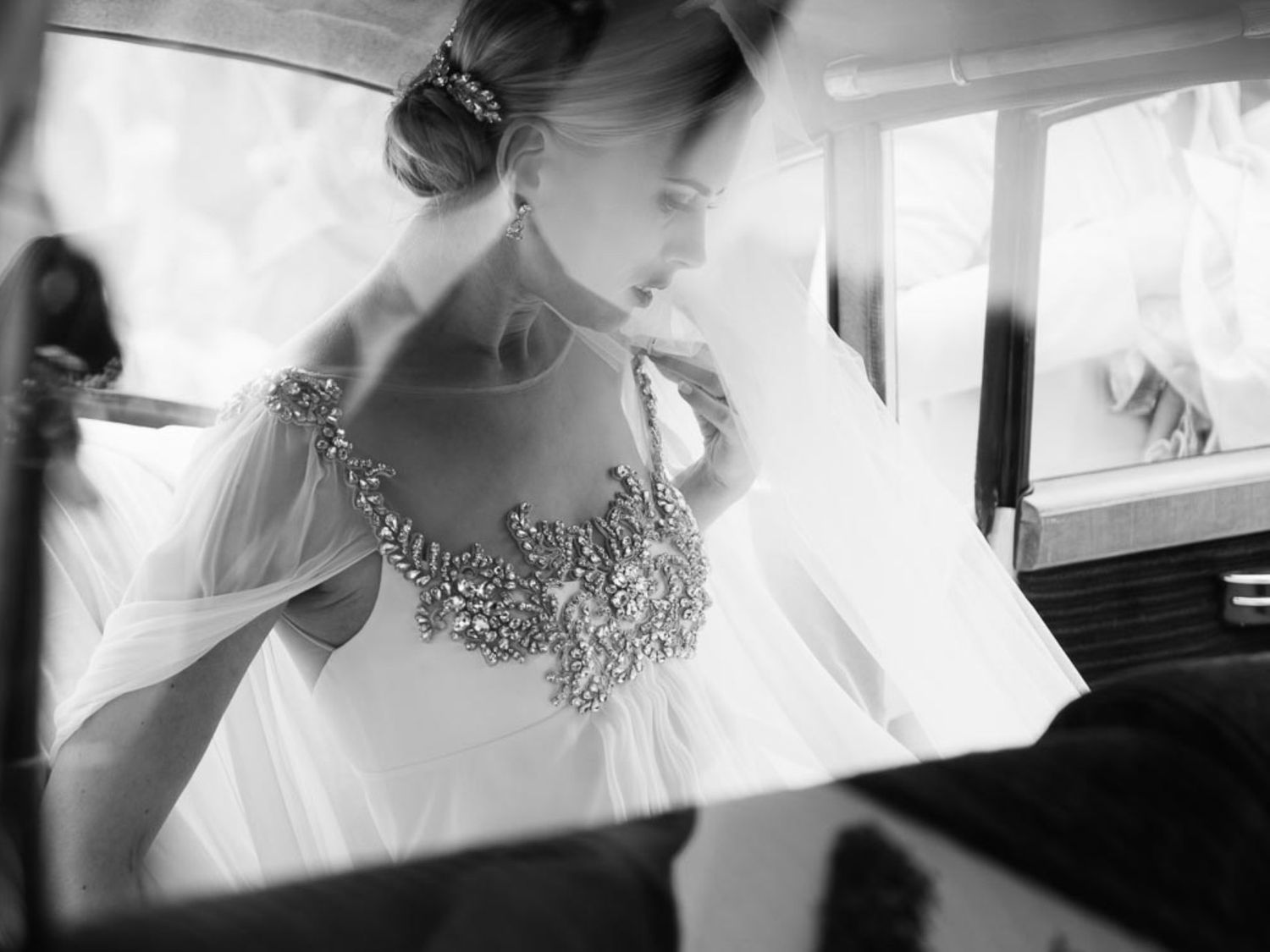 Ethereal black and white photo of a bride in an embellished gown through soft focus.