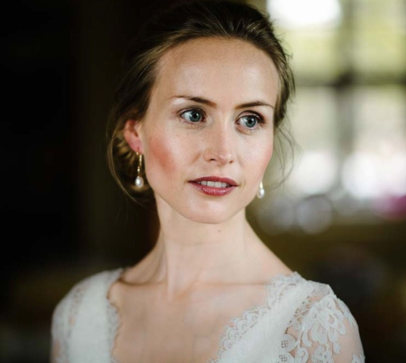 Close-up bridal portrait showing delicate lace details and natural makeup.