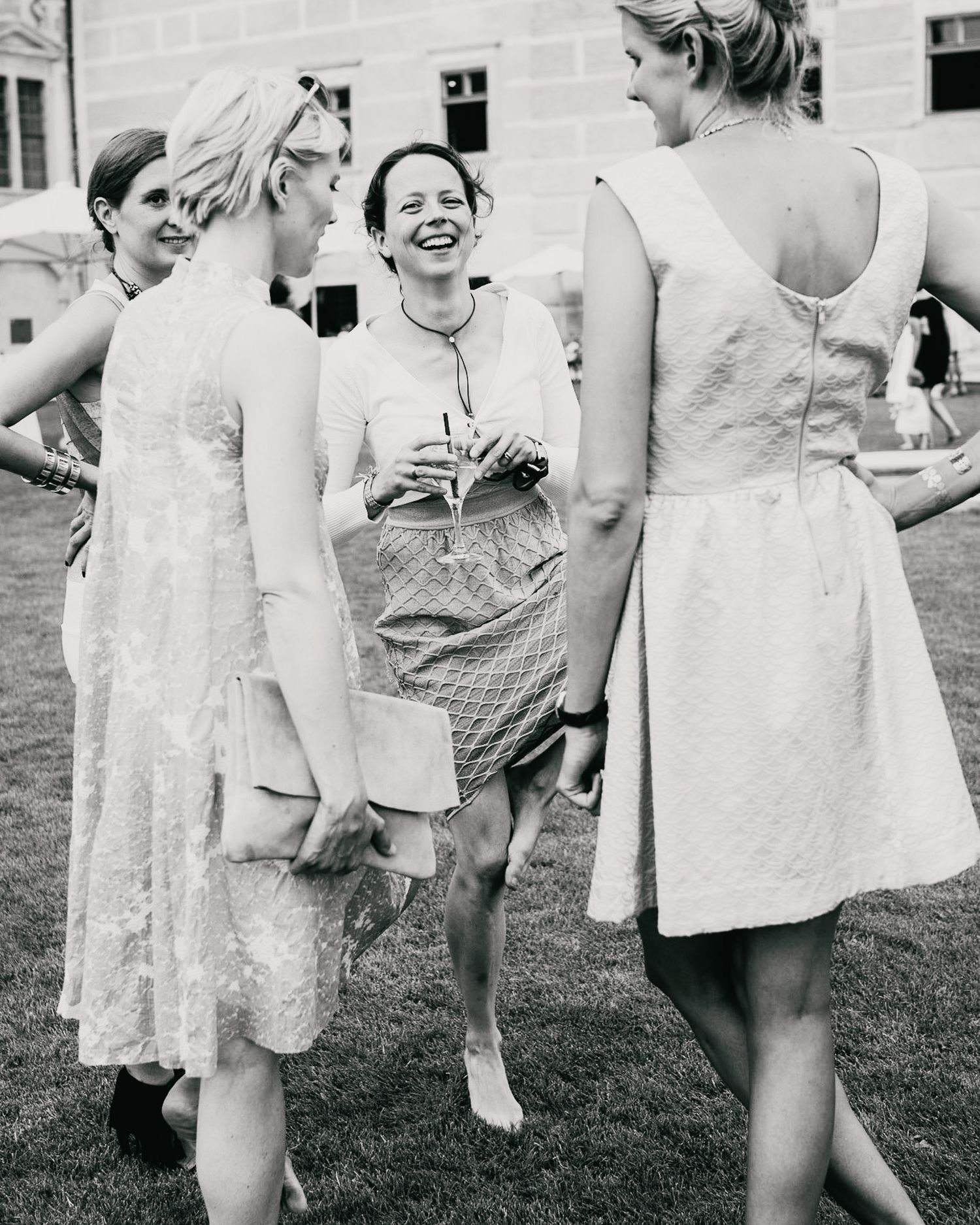 Vintage photograph of a cheerful outdoor summer gathering in light dresses.