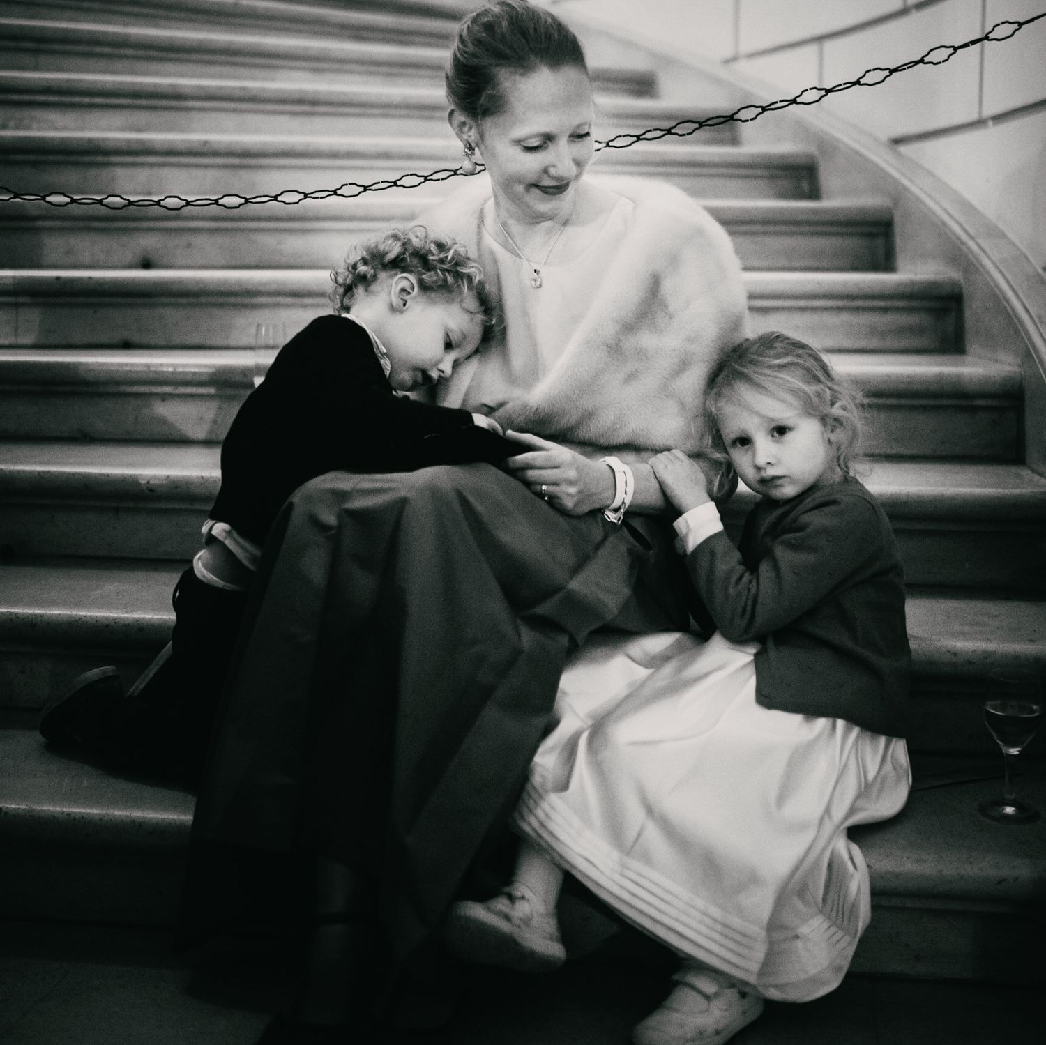Intimate black and white photograph of a tender moment on stairs.