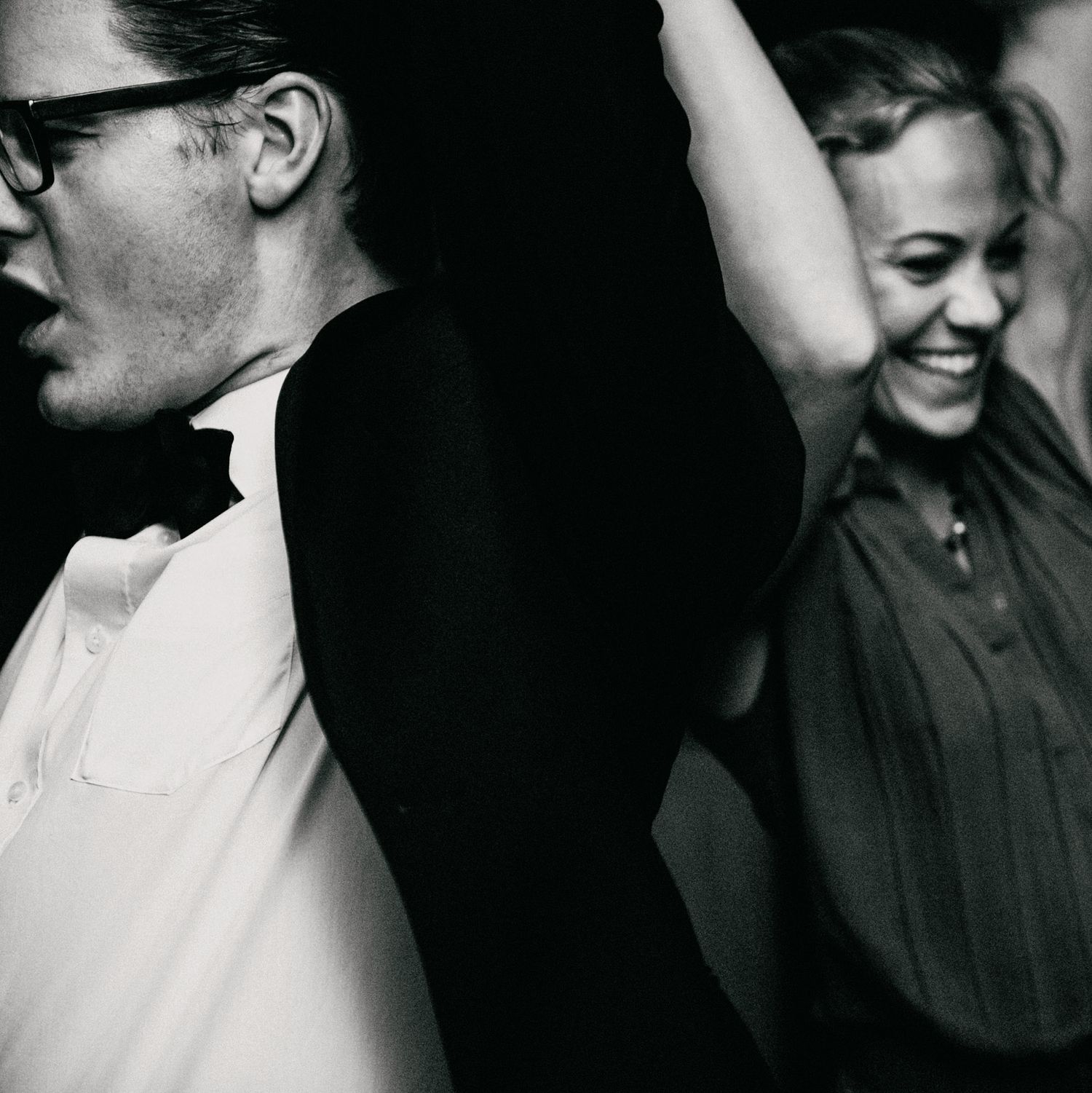 Candid black and white photograph showing contrasting joyful expressions in profile.