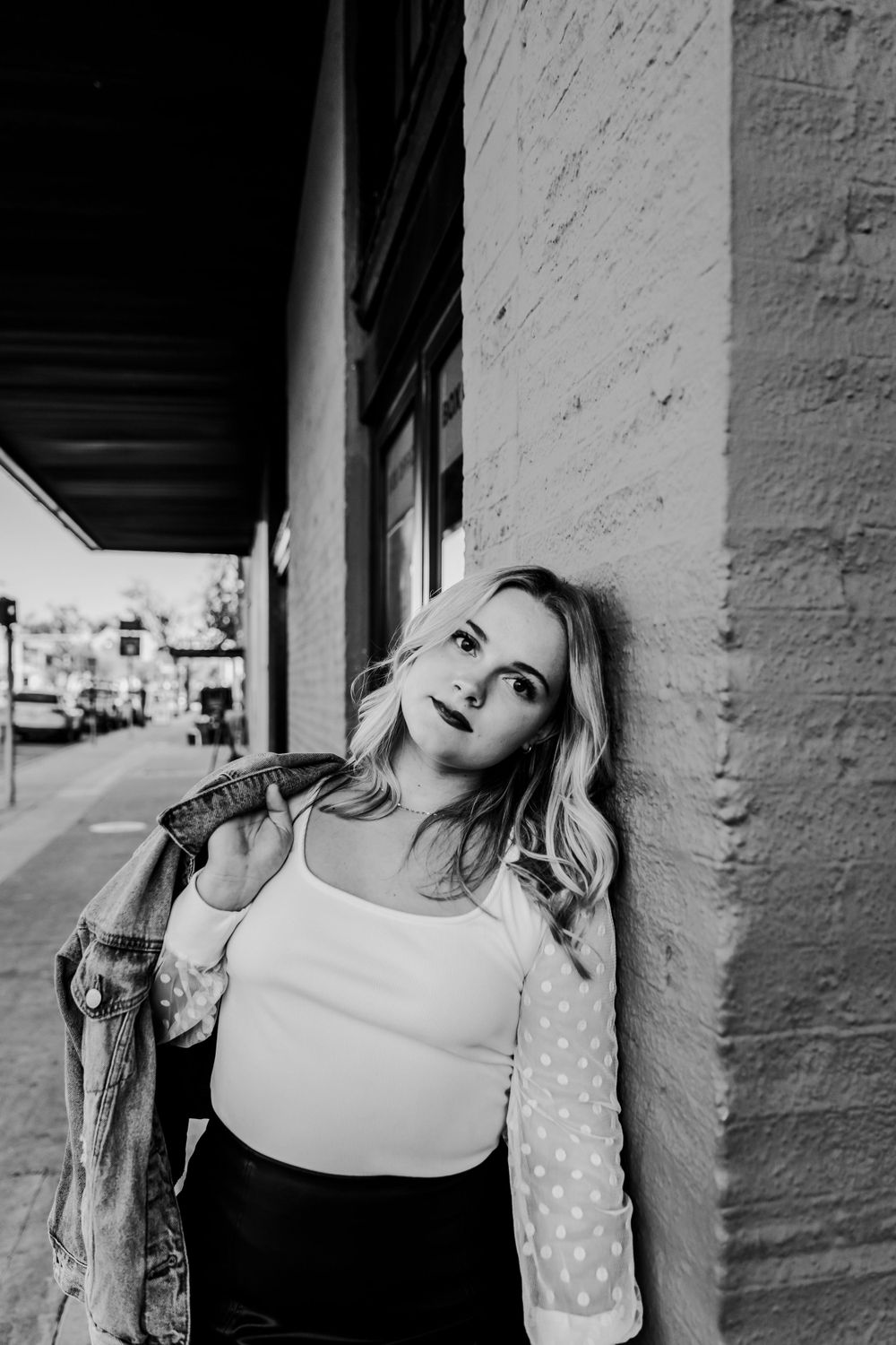 Artistic black and white portrait series against a white wall with dramatic shadows and poses.