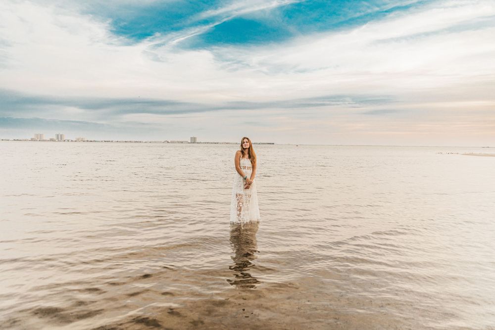 Ethereal beach photography with soft lighting and calm waters stretching to the horizon.