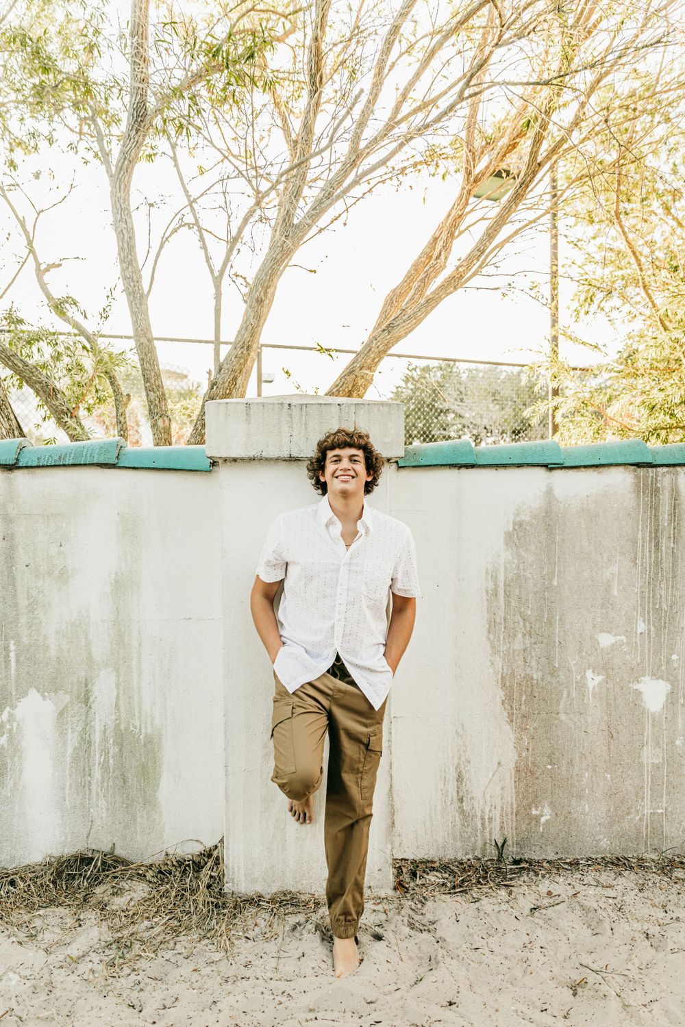 Light and airy portraits against a white wall with natural poses and casual styling.