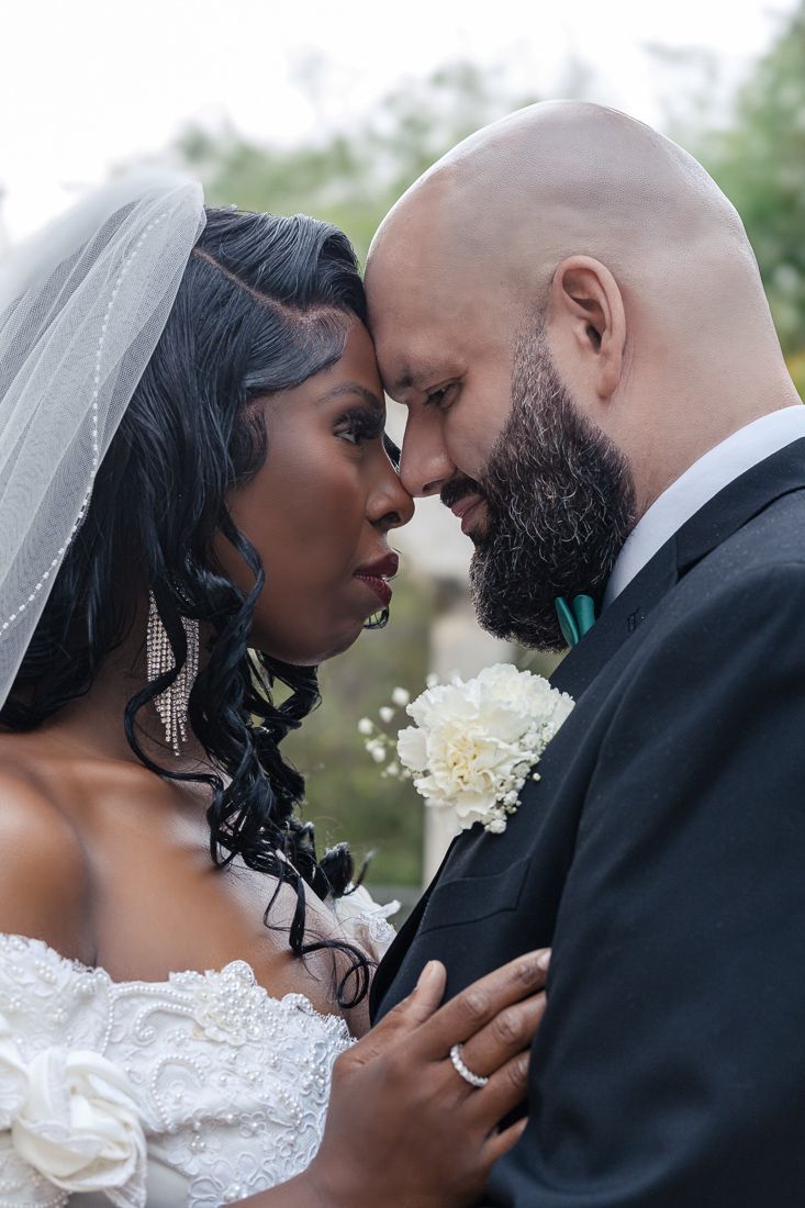 Intimate moment between newlyweds as they share a close embrace during wedding portraits.