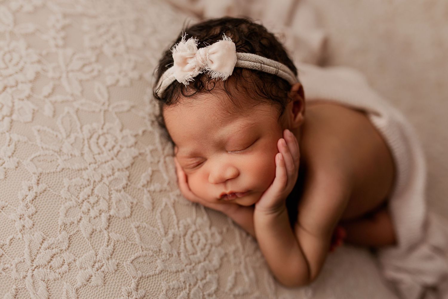 Baby girl with pink bow sleeping on pink floral blanket in Flowertown Photography Studio in Summerville SC