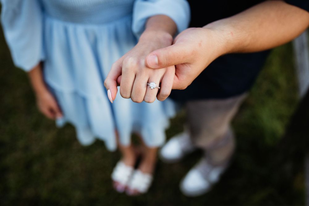 Close-up of hands clasped together showing casual engagement or romantic moment.