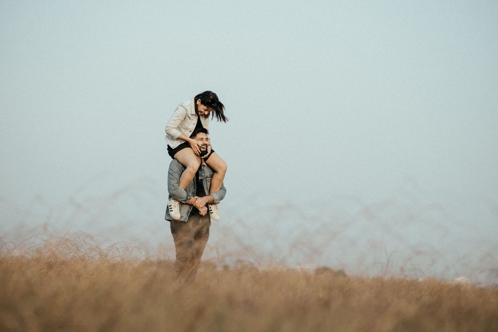 Candid moments captured between two people in a rustic field setting.