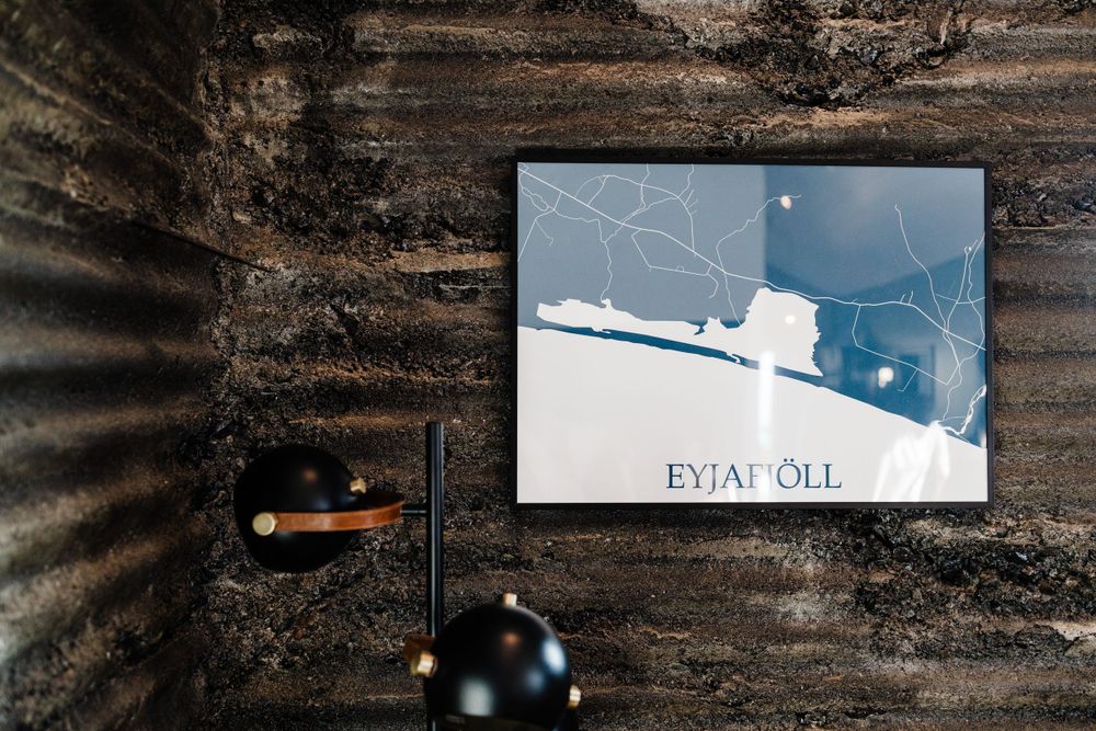 Modern minimalist map art print of Evian displayed with black decor elements against textured wall.