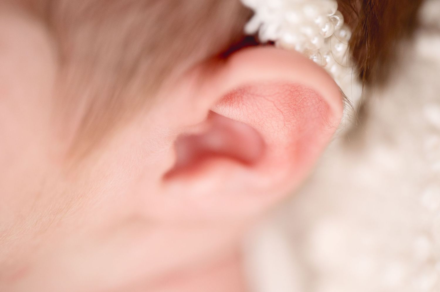 Extreme close-up macro shot of a baby's ear with soft lighting.