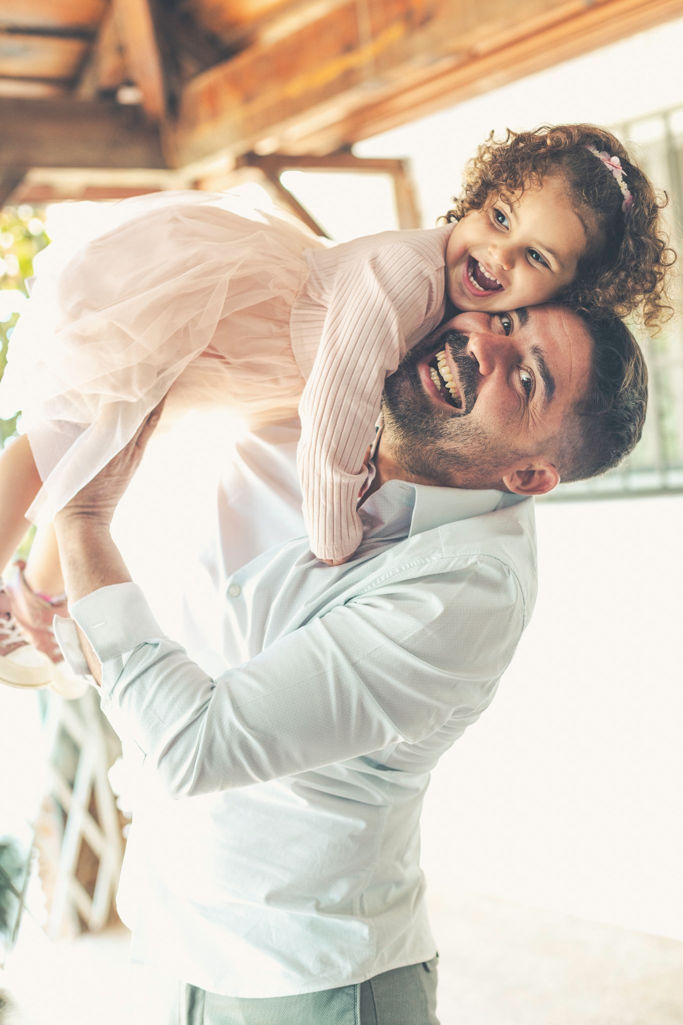 Daddy lifts Lara up, squeezes her cheek, and has some fun during the Christmas photo session