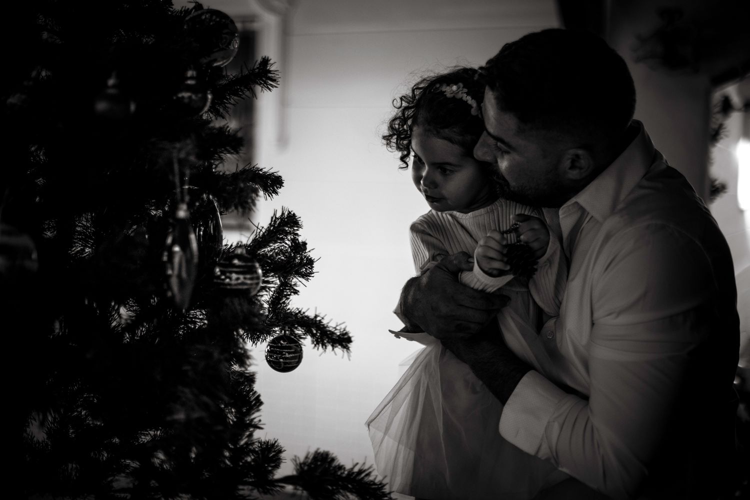 Niña y su padre mirando el árbol de Navidad