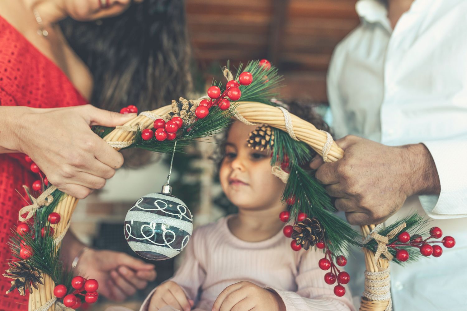 Mummy and daddy are holding the Christmas basket while Lara is sitting inside.