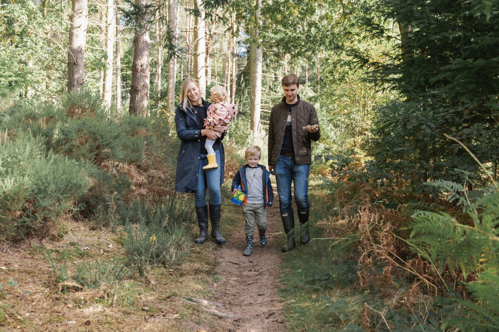 photograph of family walking through woodland path