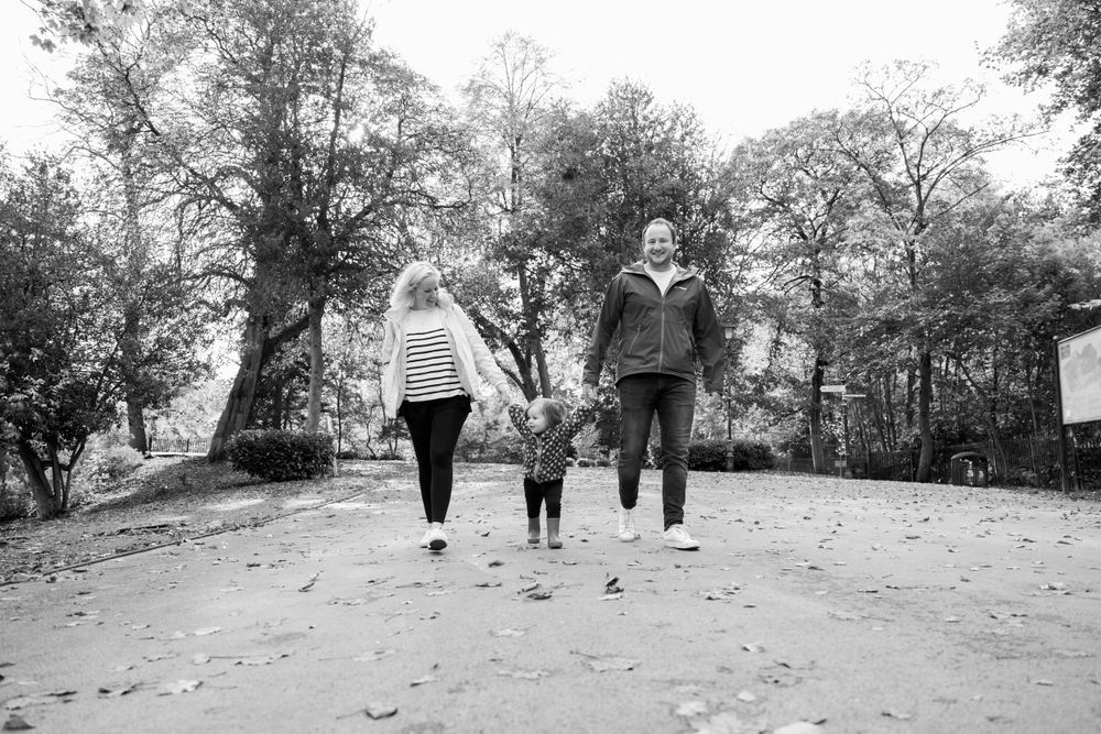 black and white photograph of family walking along park path