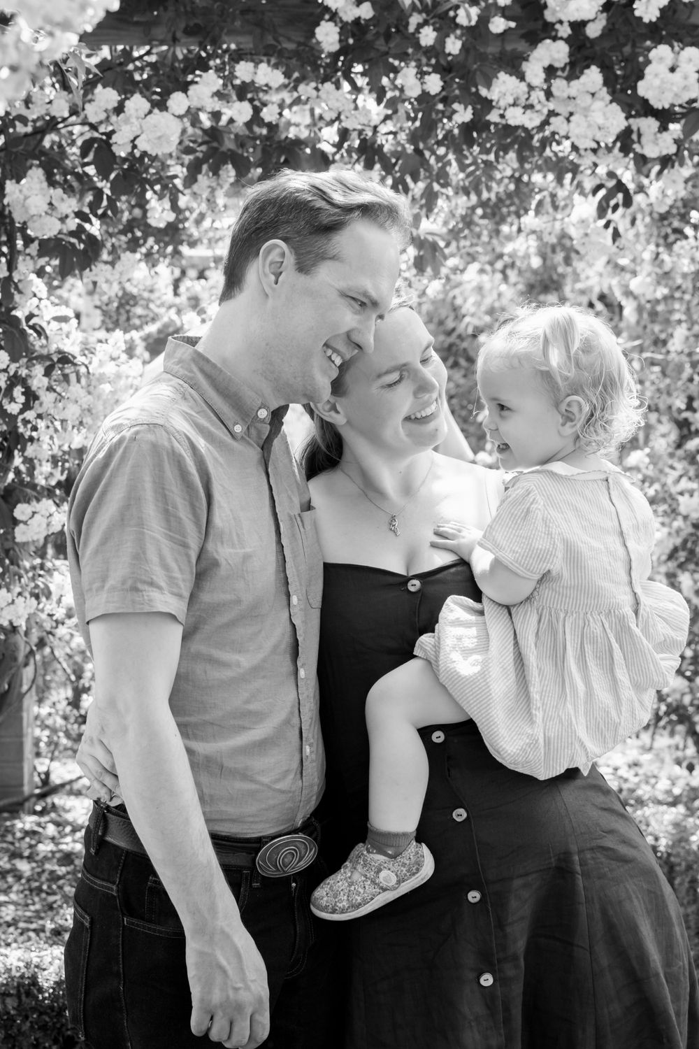 black and white photograph of family smiling in rose garden