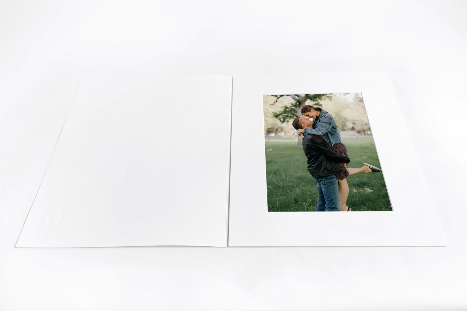 matted print of husband picking up wife in a field