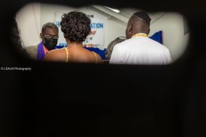 Candid behind-the-scenes photo through doorway of wedding preparations.