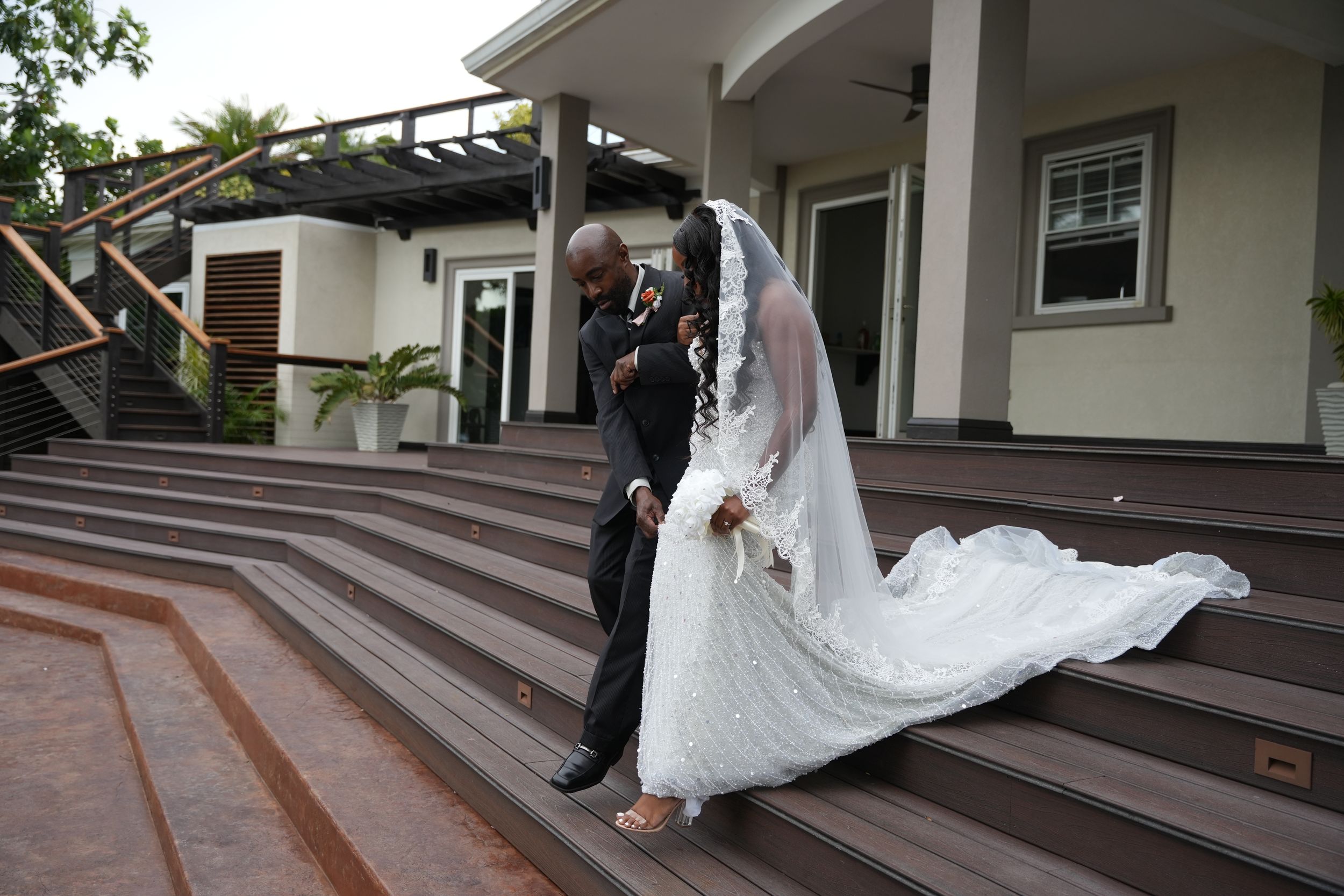 Couple walking down wooden steps at a wedding venue.