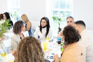 Diverse group of guests gathered around tables at a social event.