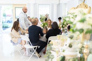 Guests seated at round tables enjoy conversation during an indoor celebration.