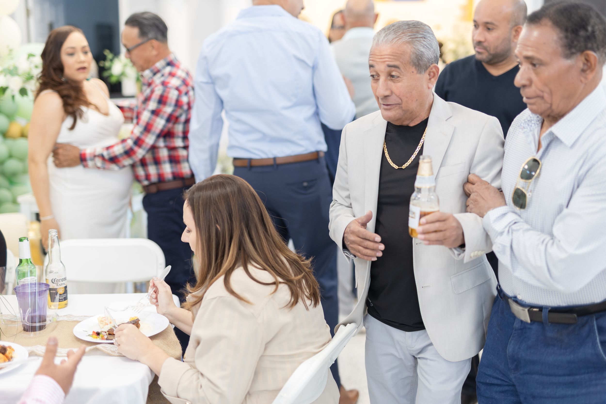 Casual party scene with guests mingling in bright indoor space.