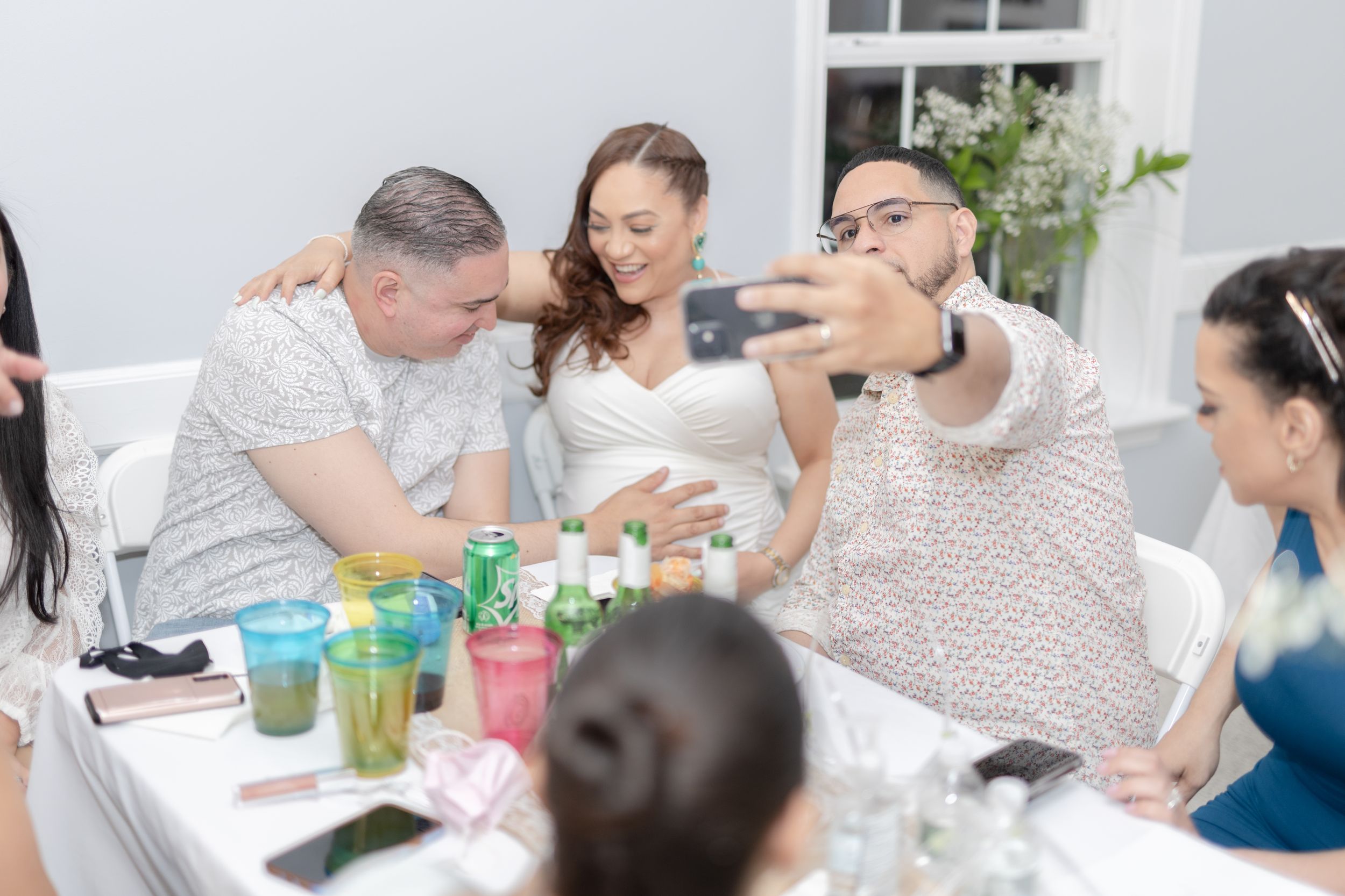 Group gathered around table enjoying colorful drinks at casual social gathering.