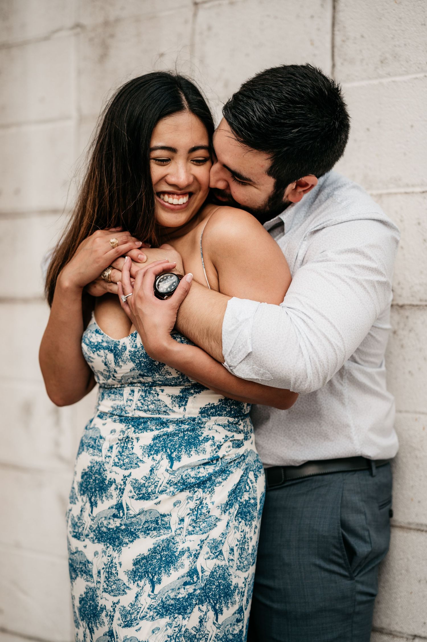 engagement photo showing ring display against urban wall background.