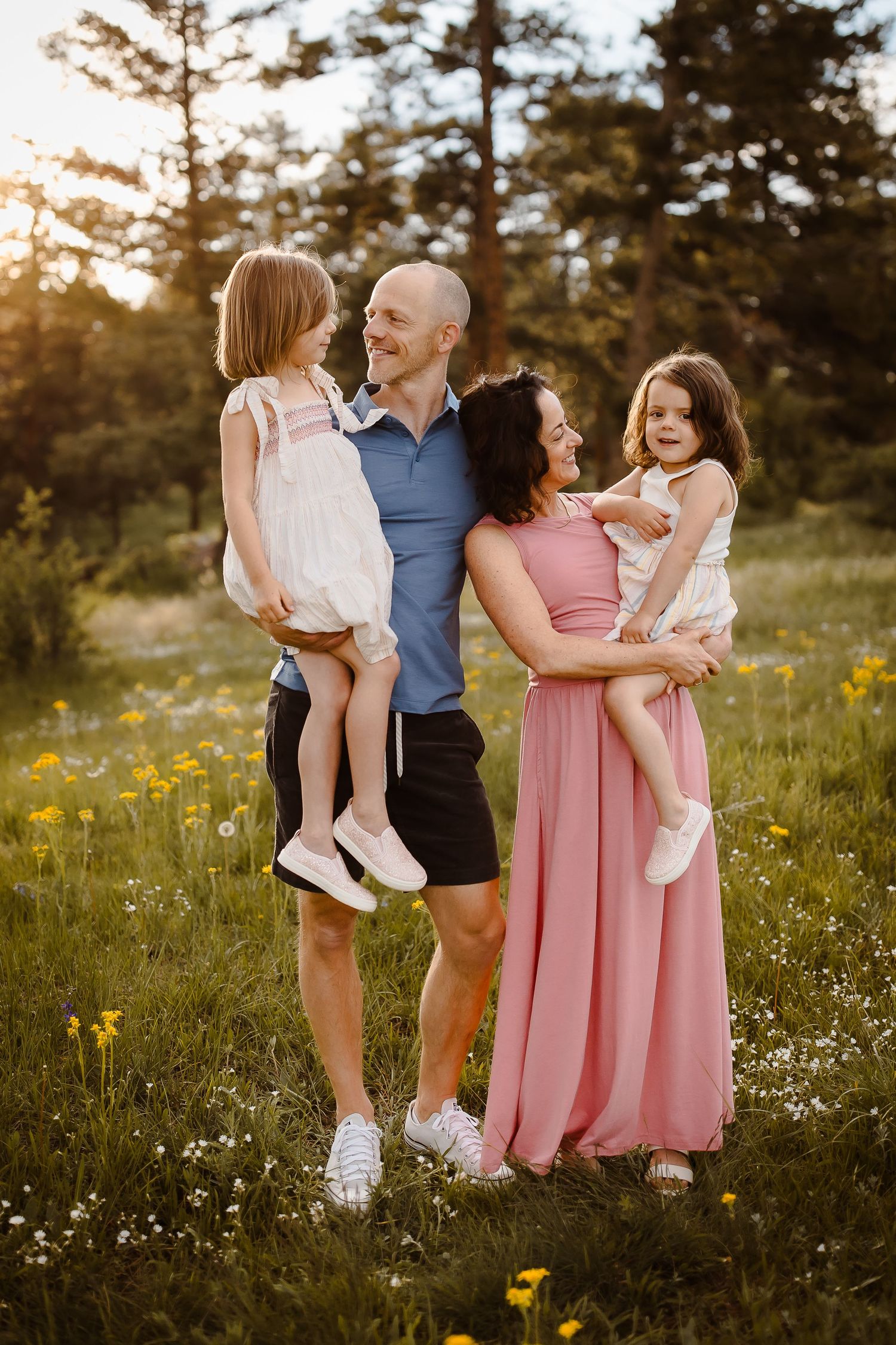 Family of four smiling candidly in a golden hour Denver, Colorado flower field