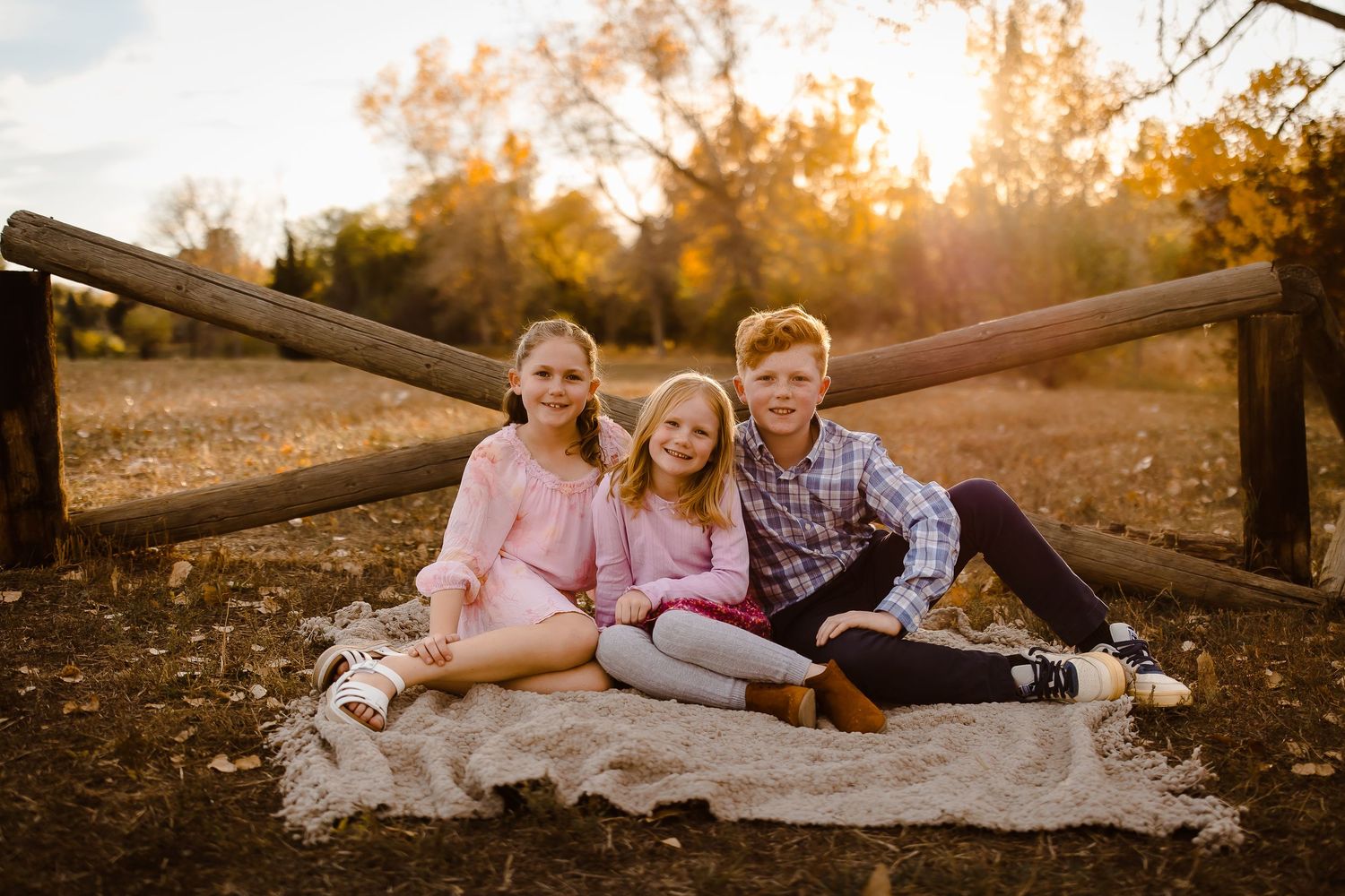 Three children smiling in Cherry Hills Village, Colorado in natural golden hour light