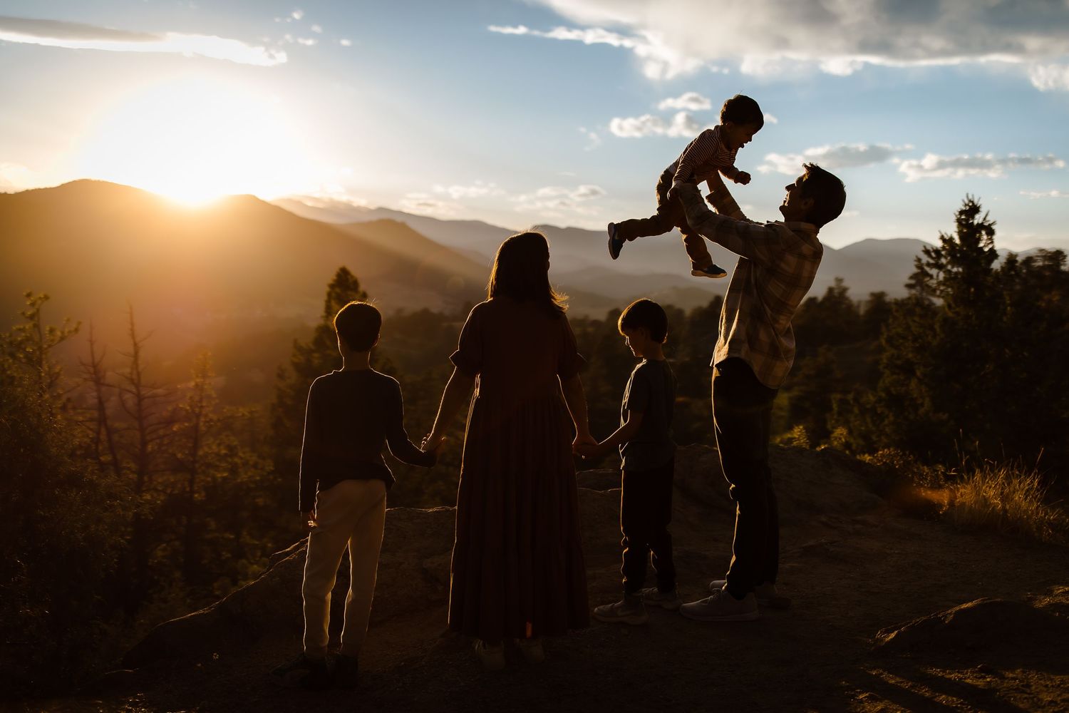 Silhouette of a family of five playing candidly with a bright Denver, Colorado sunset