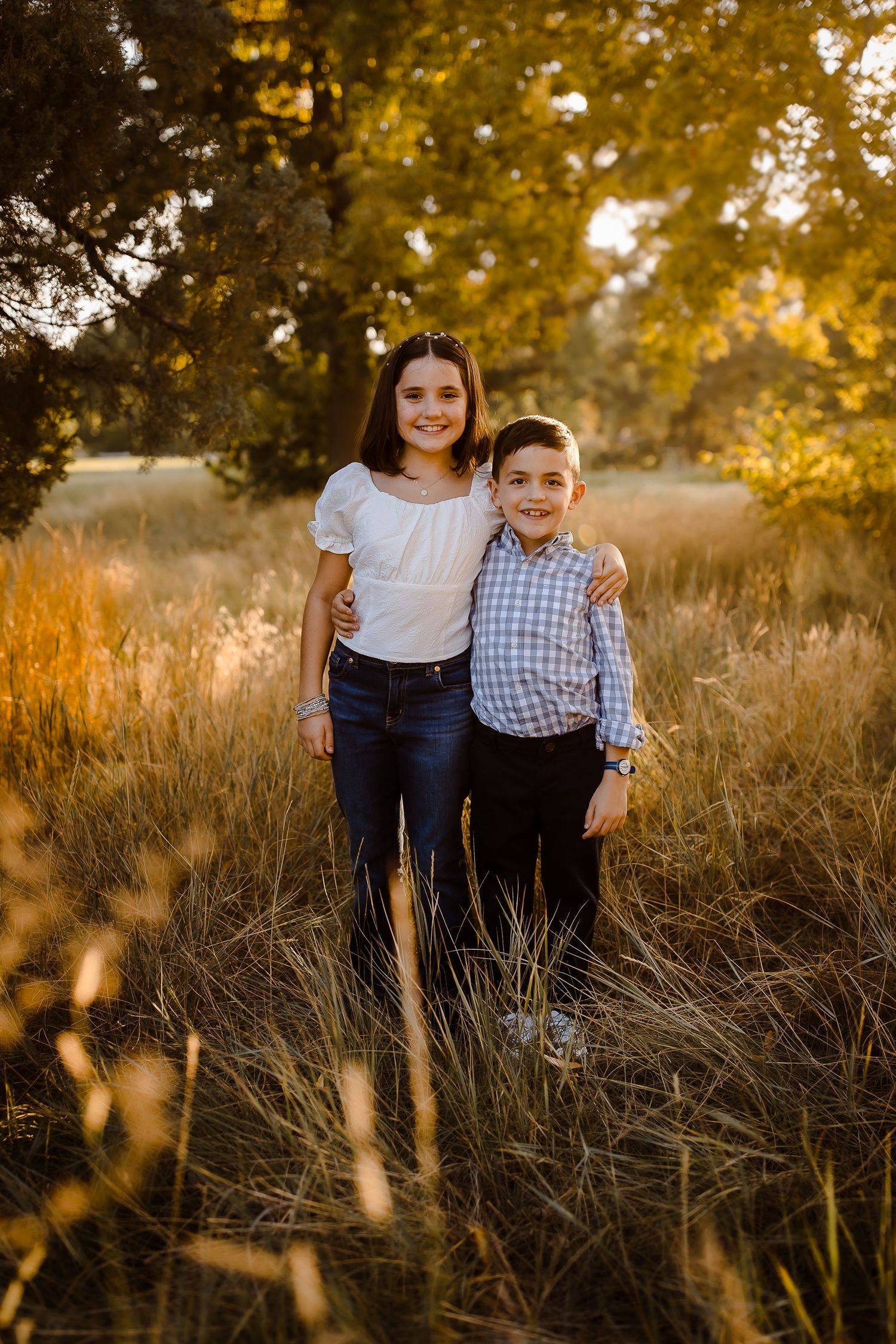 Children smiling together in Denver City Park at golden hour