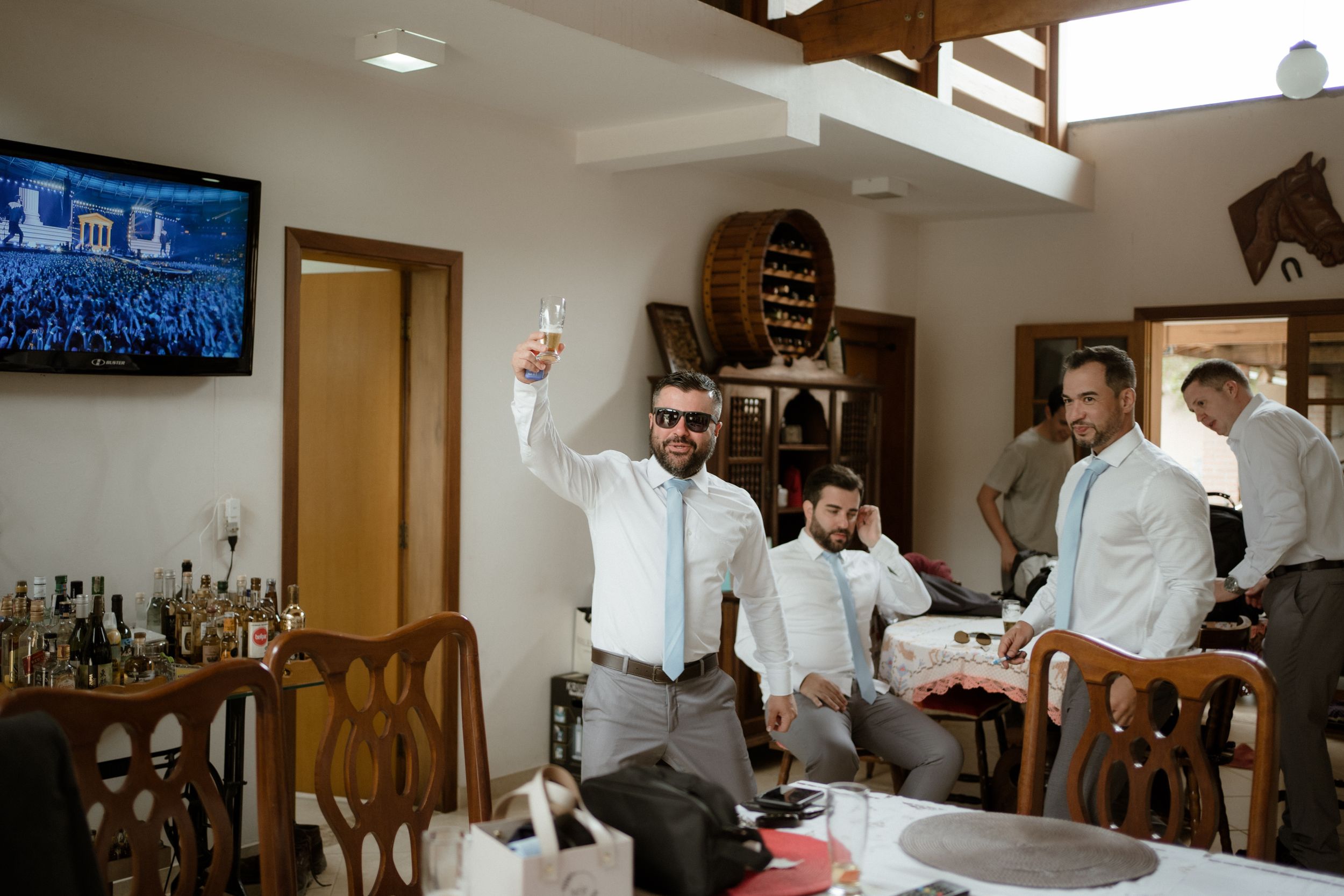 Group of people in white shirts celebrating in a dining room with drinks.
