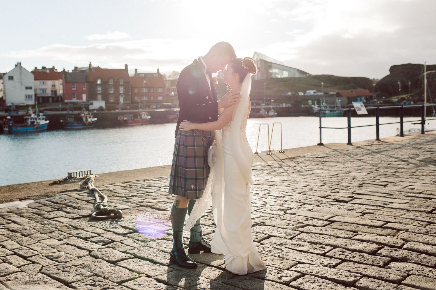 A romantic waterfront photo session on historic cobblestone streets at golden hour.