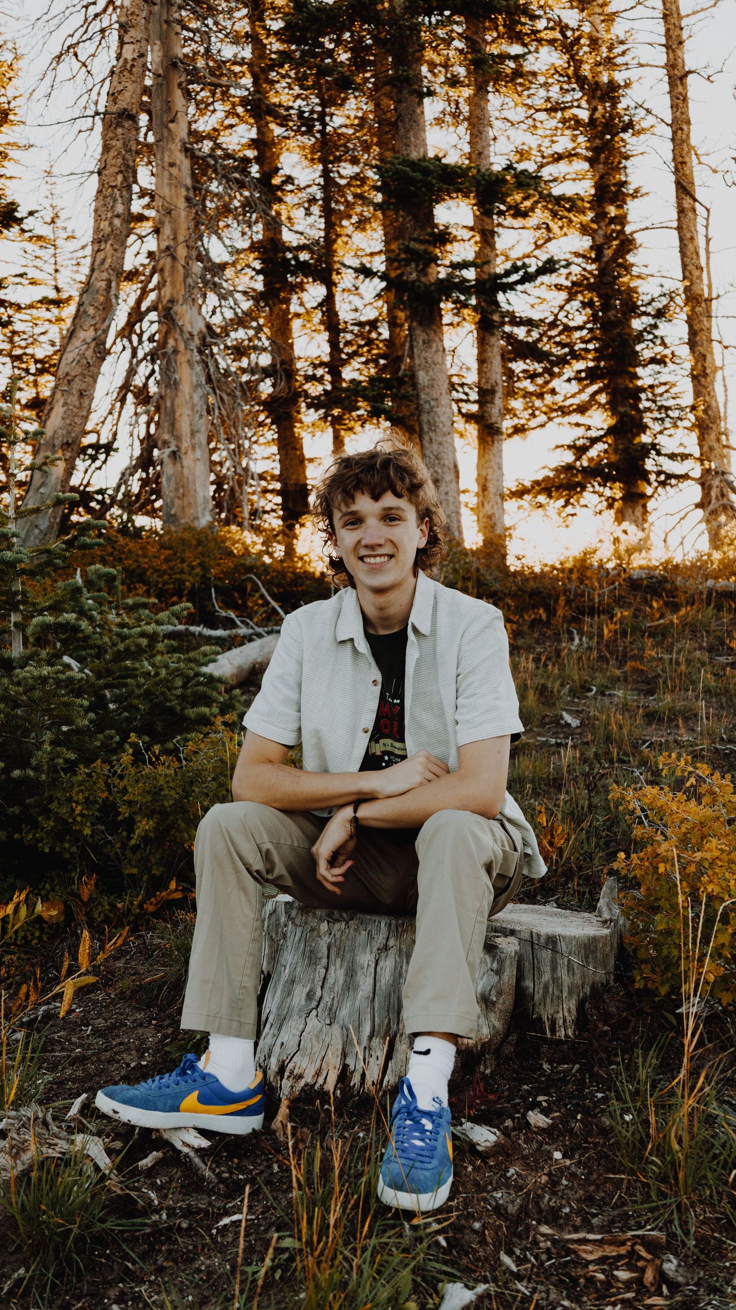 A portrait of a person smiling, captured in natural light, with a simple background.