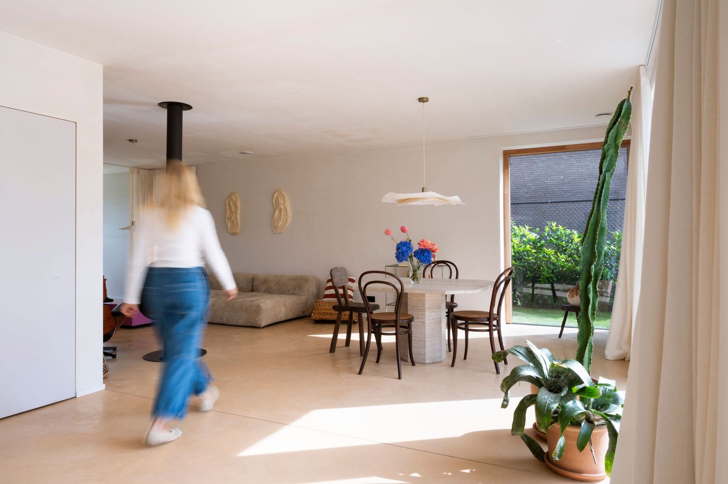 Bright minimalist interior with white walls, hardwood floors and natural light streaming through windows.