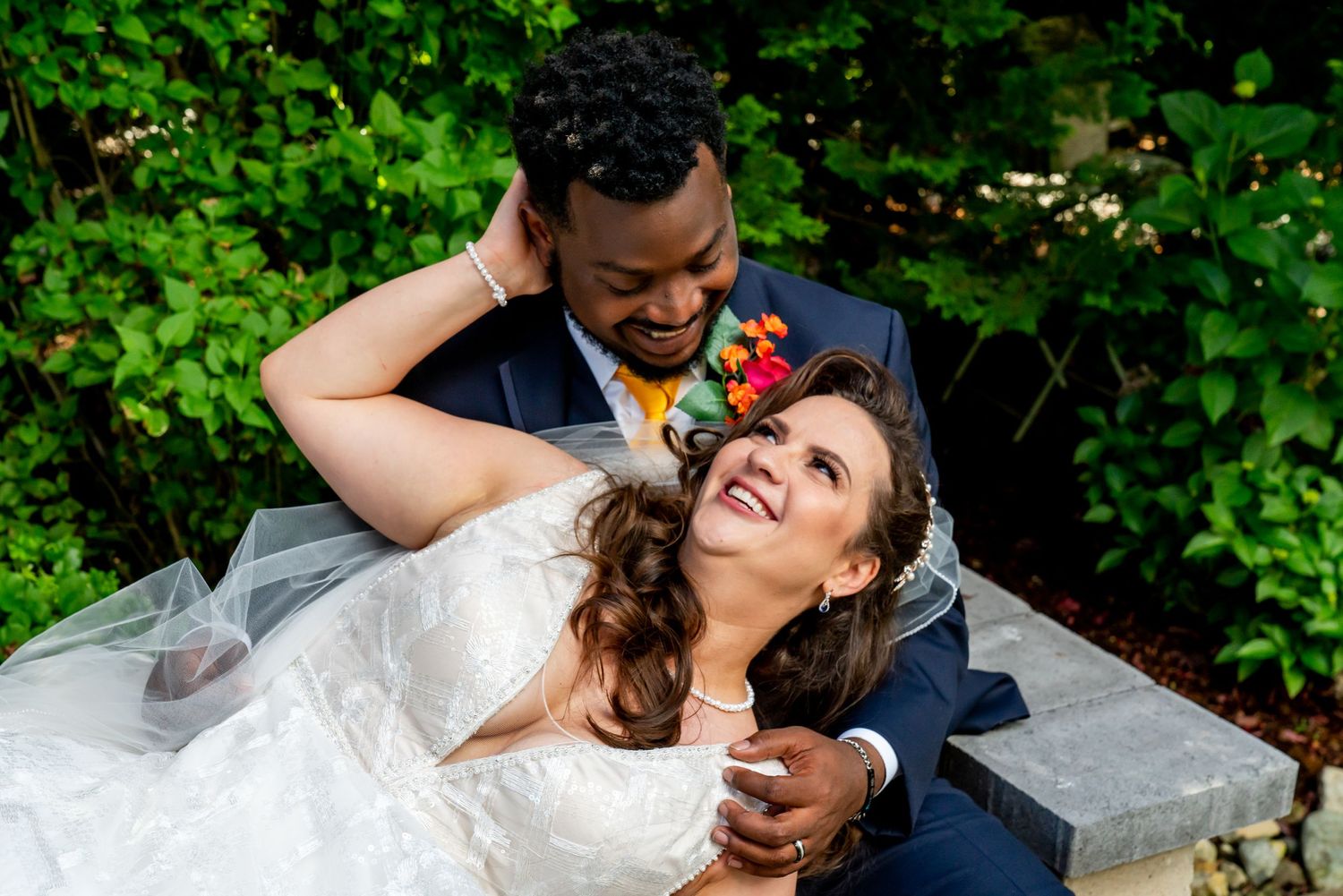 Wedding couple shares romantic moments in a lush garden setting.