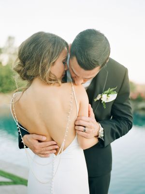 A romantic wedding photo showing a tender moment between newlyweds with the bride in a backless white dress. Timeless wedding in Lake Tahoe