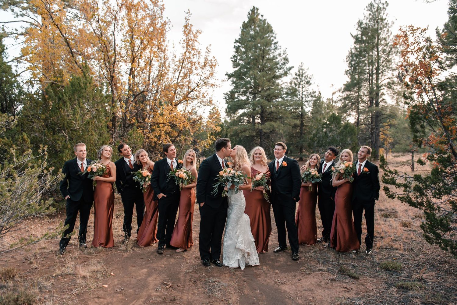 Wedding party stands in formation against scenic mountain backdrop with fall foliage.