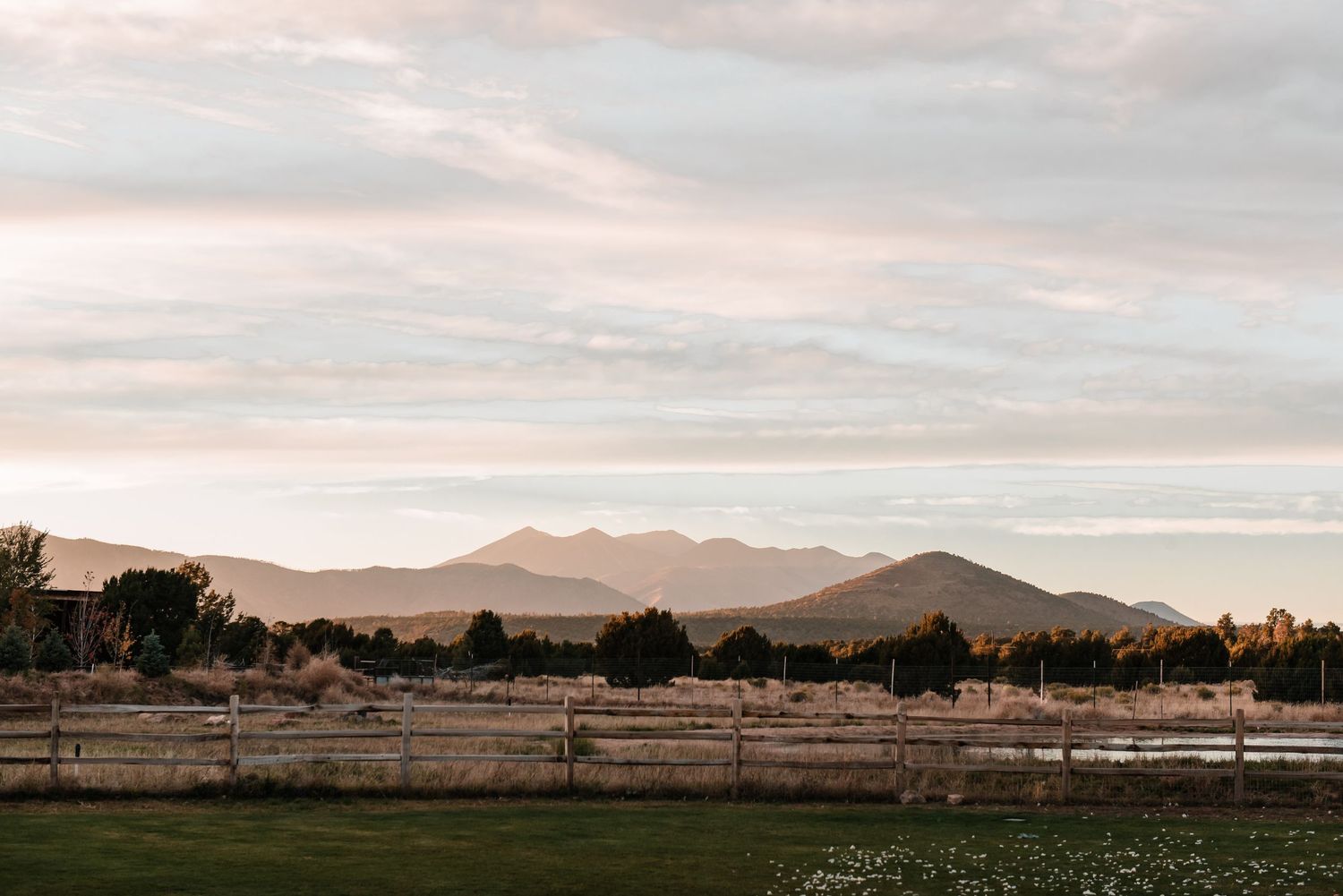 Scenic mountain landscape at sunset with rolling hills and pastures.