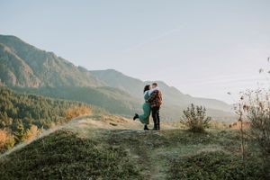 couple kissing on top of green hill at sunset in the Columbia River Gorge