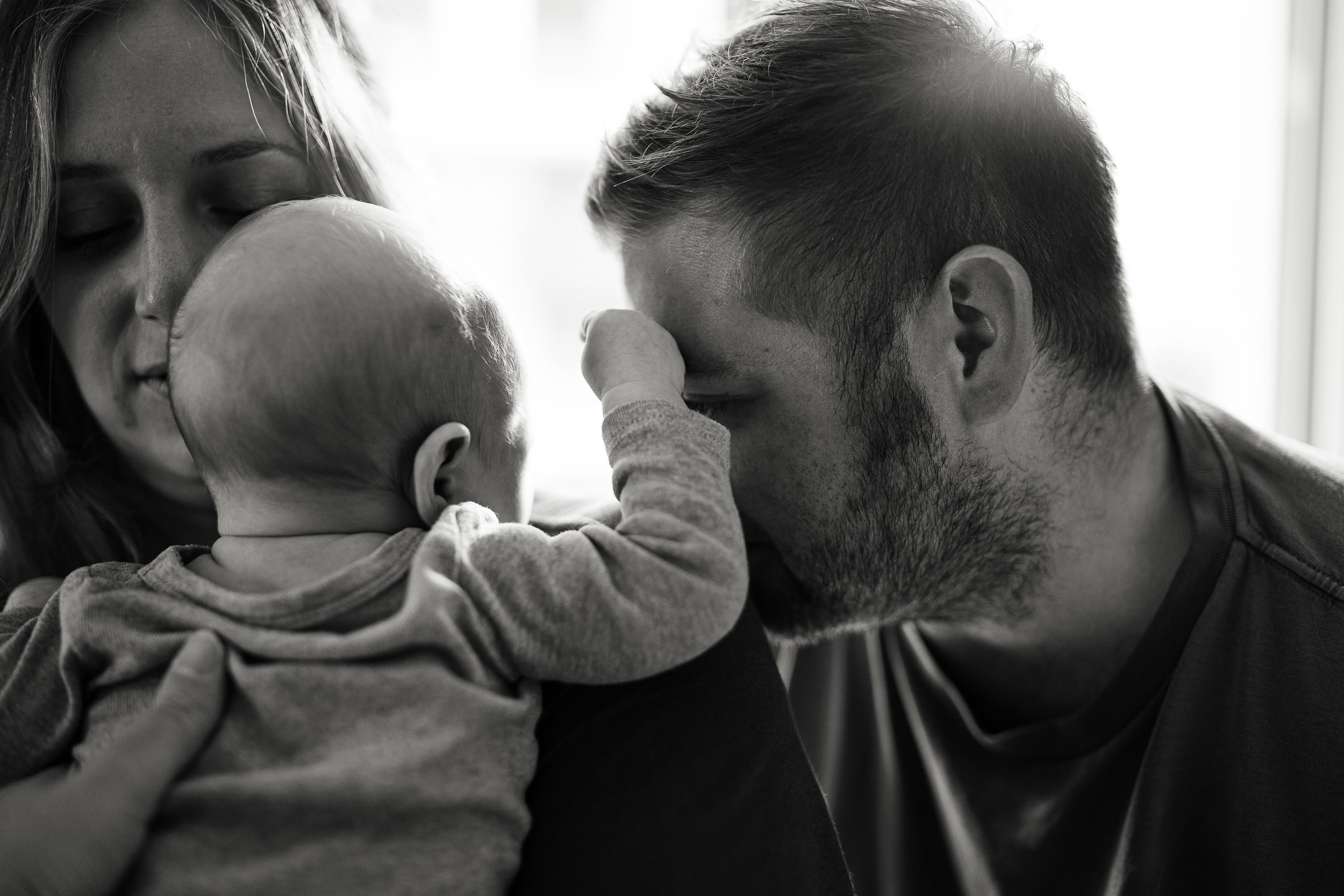 A touching black and white family moment with an infant.
