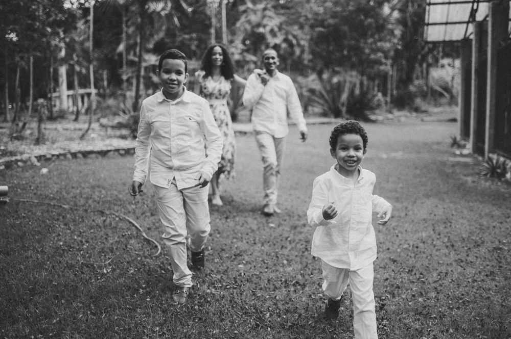 Black and white photo of family running and playing together on outdoor path.