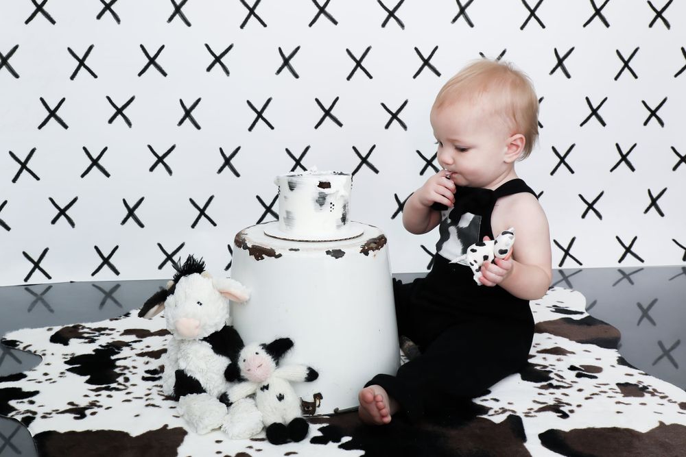 Black and white modern cake smash setup with geometric pattern backdrop.
