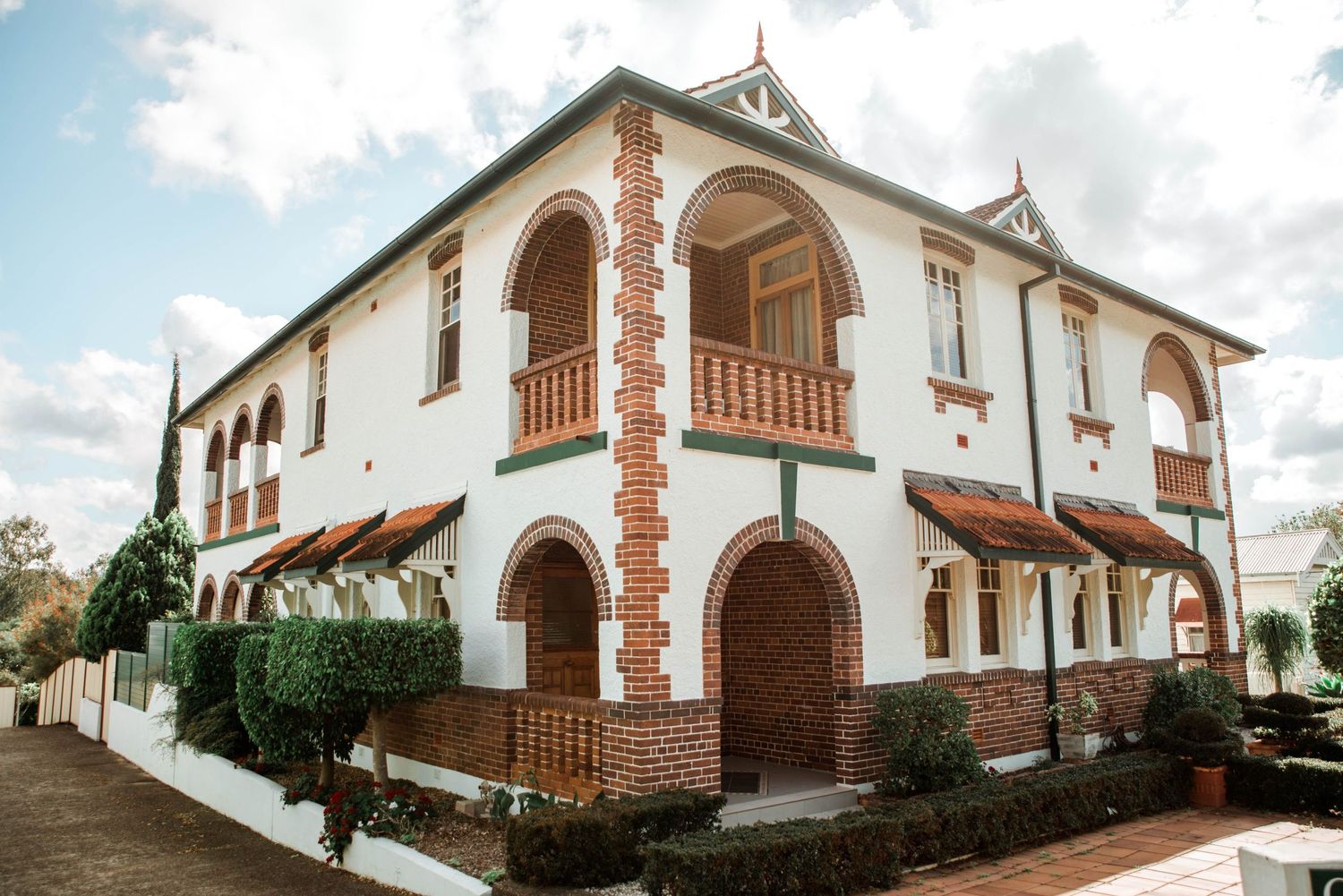 Spanish colonial style white building with arched balconies and terracotta accents.